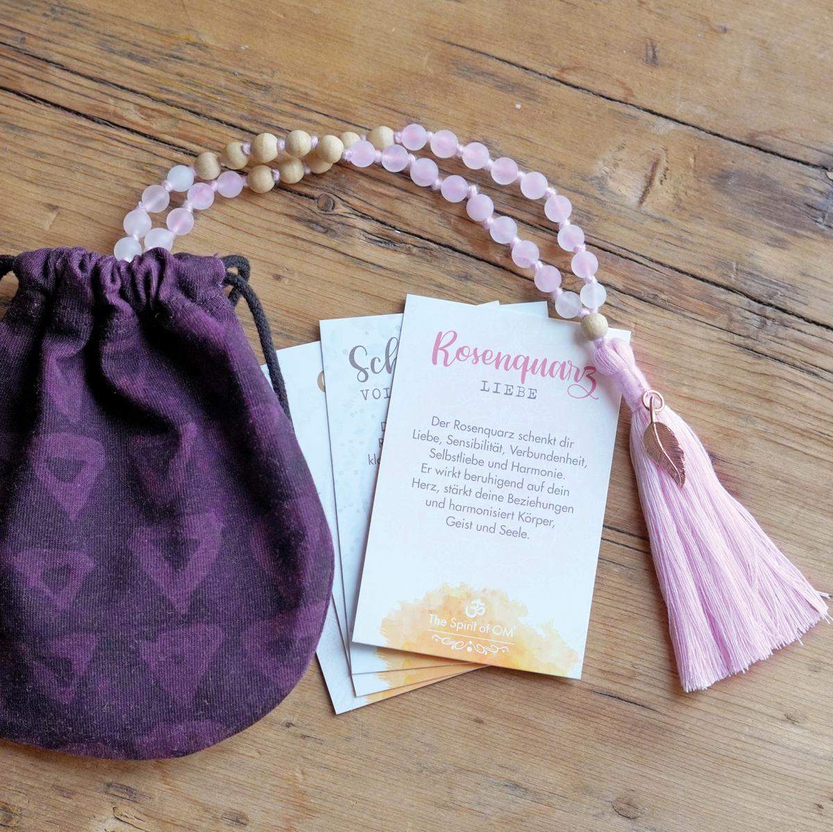 Mala aus Rosenquarz und Schneequarz von Spirit of Om mit Sandelholz im lila Beutel