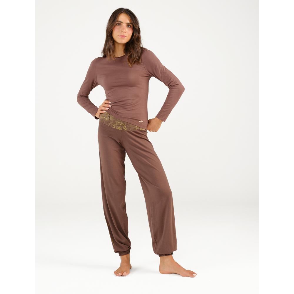 Model trägt die cacaobraune Yoga Hose Bali von Spirit of OM mit passendem langärmeligen Oberteil.