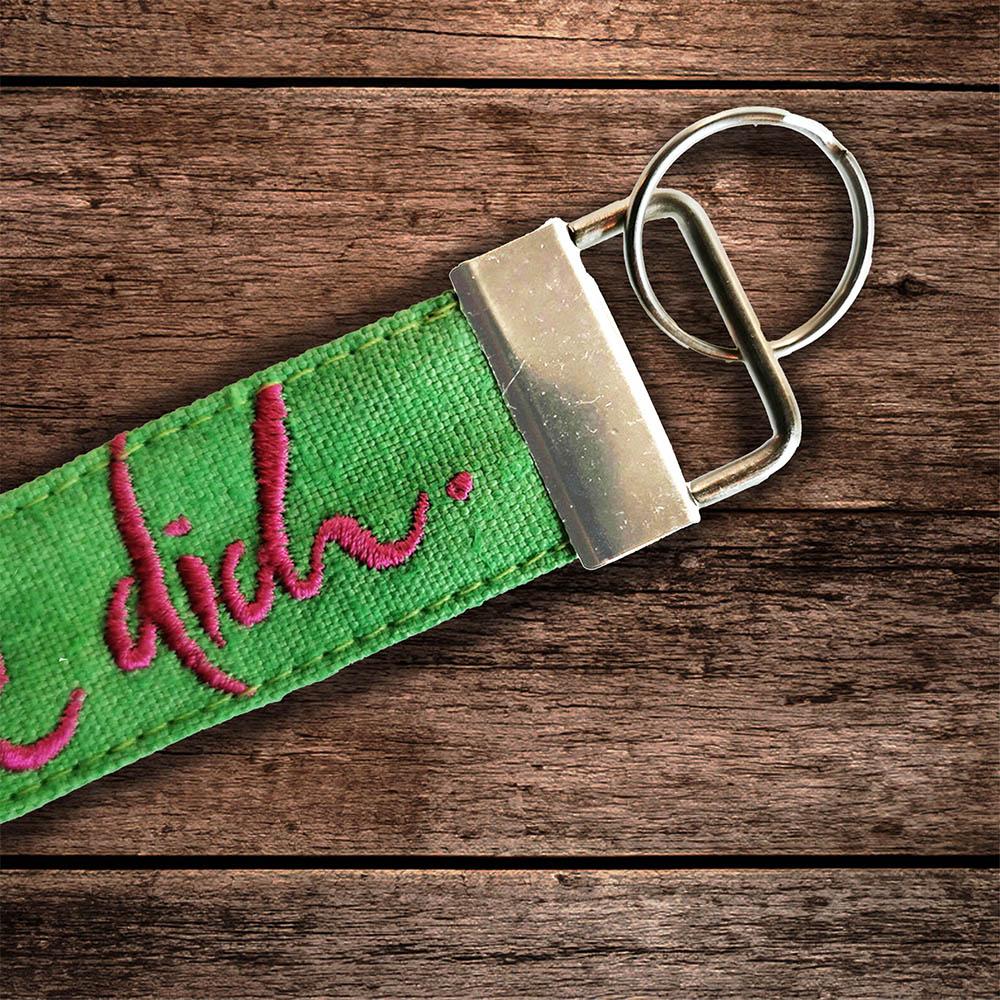 Schluesselanhaenger von Signs by Jwala mit der Stickerei 'Ich sehe dich' in gruen in Nahaufnahme