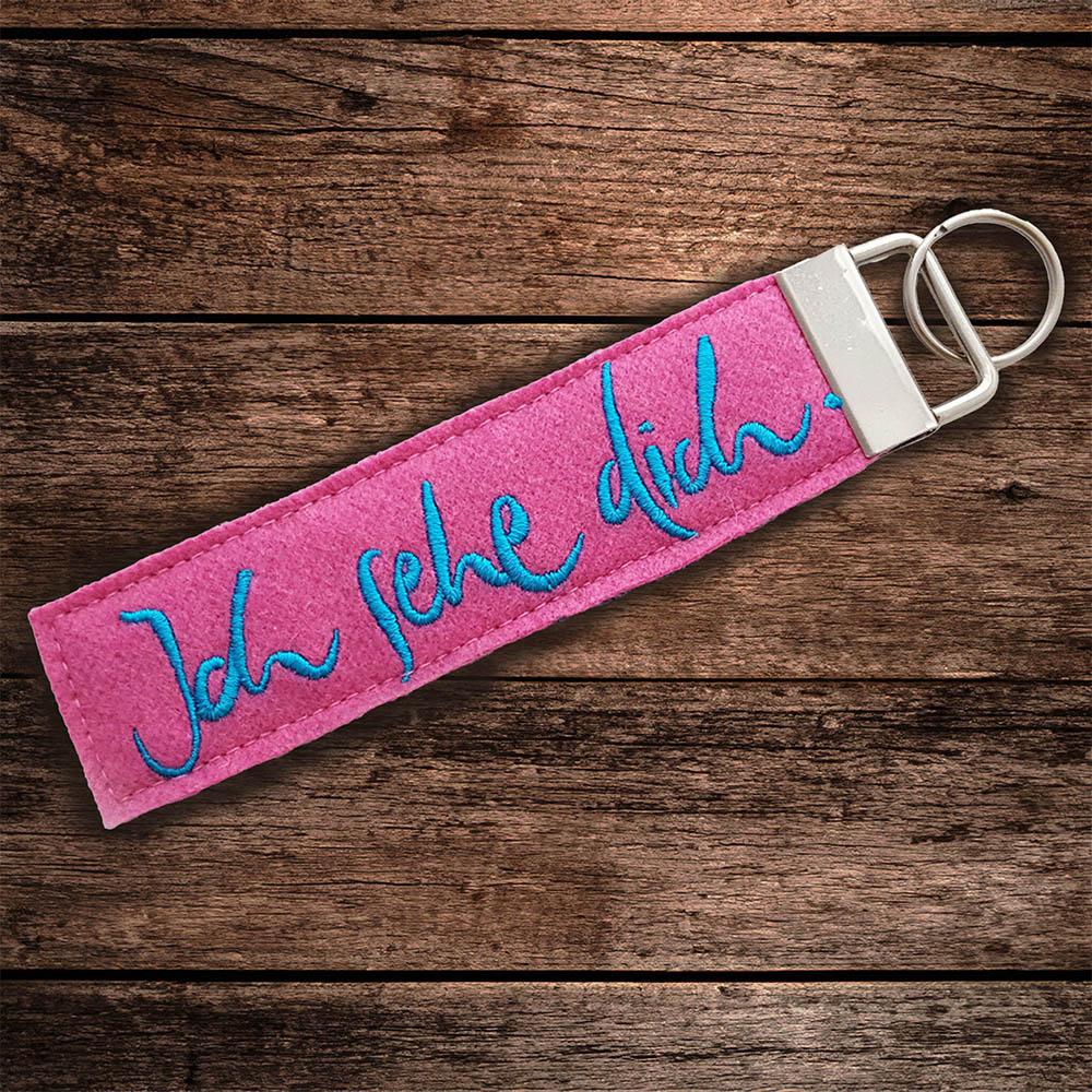 Schluesselanhaenger von Signs by Jwala mit der Stickerei 'Ich sehe dich' in rosa