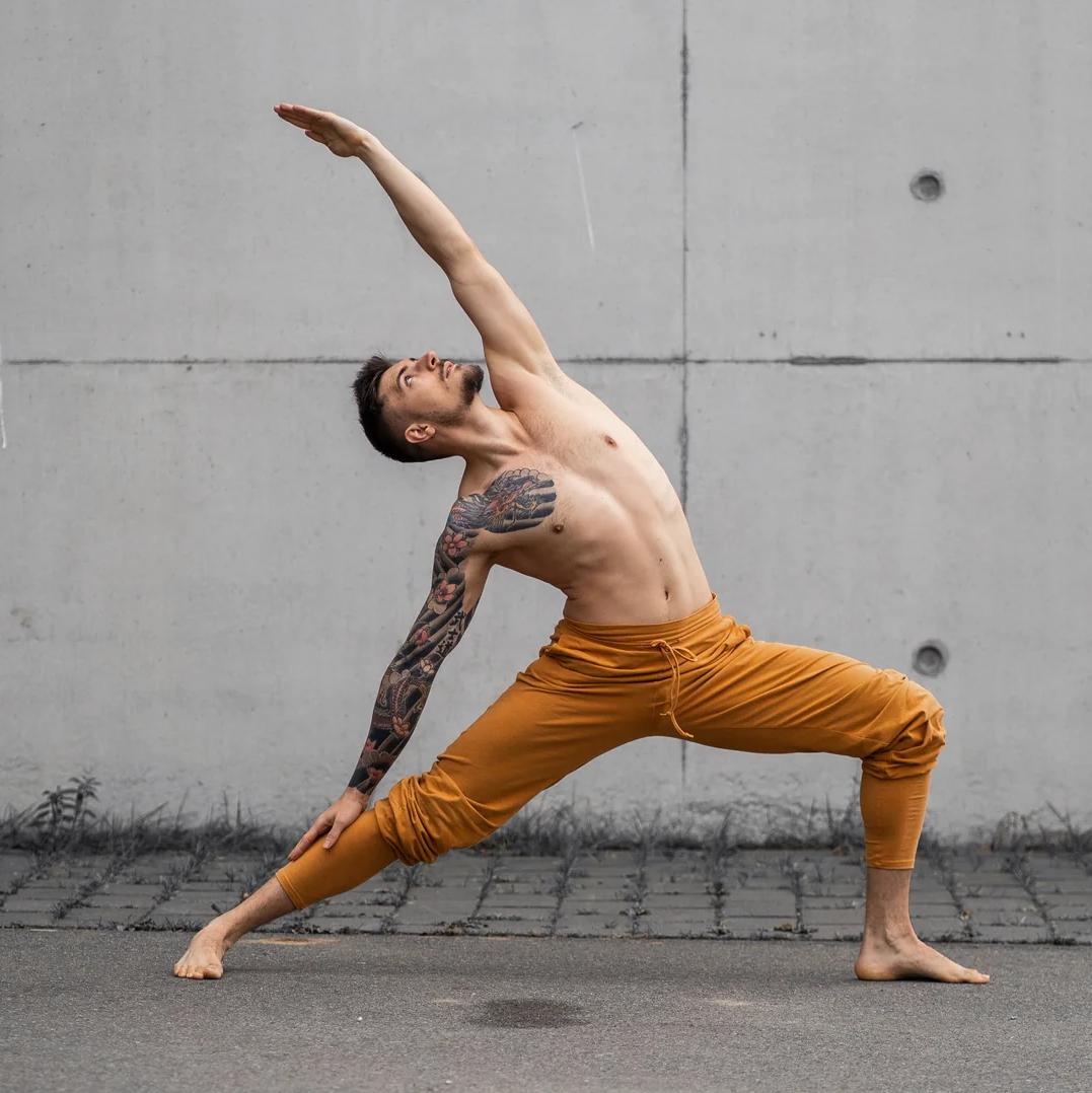 Mann beim Yoga in der Mahan Yogahose Herren Safran von Breath of Fire