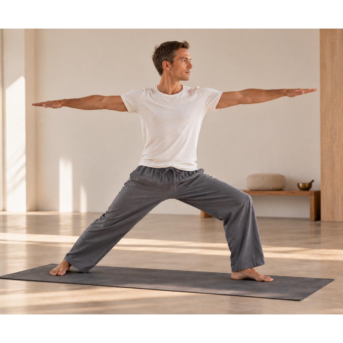 Mann trägt graue Yoga Hose aus Baumwolle im Yogastudio