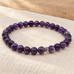 Handgefertigtes Amethyst Armband mit silberfarbener Zierperle auf hellem Naturleinen
