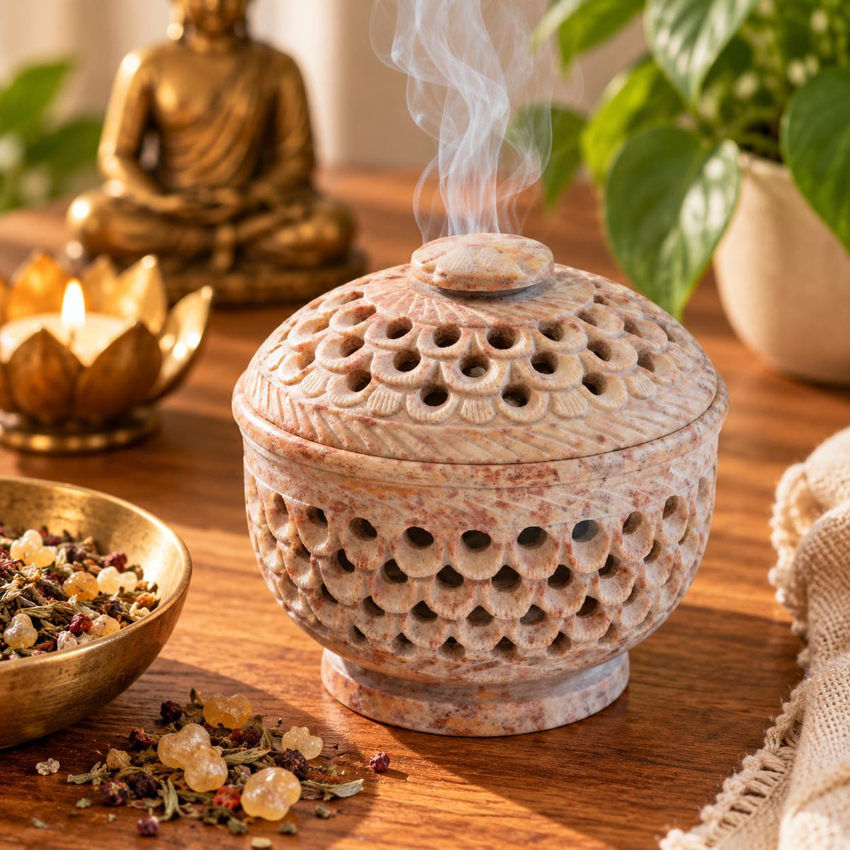 Räuchergefäß aus naturfarbenem Speckstein mit graviertem Deckel, umgeben von Räucherkräutern und Harzen in einem stimmungsvollen Meditations-Setting