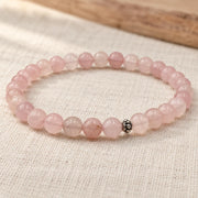 Handgefertigtes Rosenquarz Armband mit silberfarbener Zierperle auf hellem Naturleinen