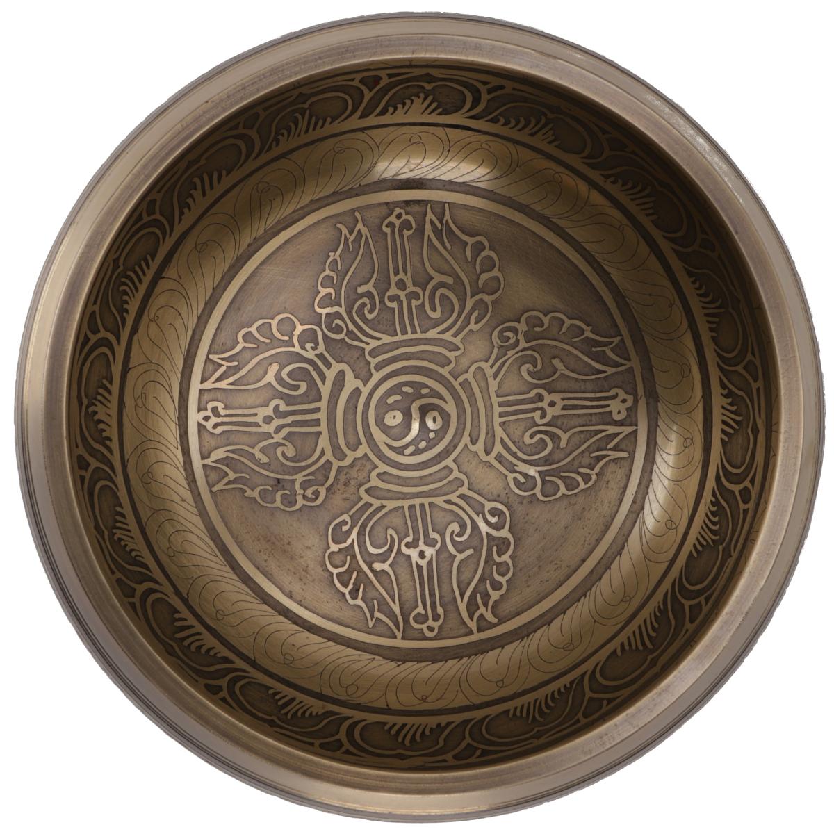 Innenansicht der tibetischen Klangschale mit zentralem Dorje-Symbol und kreisförmigen Ornamentgravuren auf Bronze.