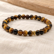 Handgefertigtes Tigerauge Armband mit goldfarbener Zierperle auf hellem Naturleinen