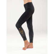 Yoga Legging Tivra von Spirit of OM in Anthrazit, seitlich getragen mit goldfarbenem Ornament am Unterschenkel