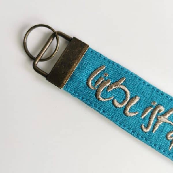 Signs by Jwala Anhaenger Liebe ist der Schluessel tuerkis beige mit Stickerei